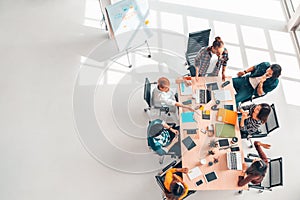 Multiethnic diverse group of business coworkers in team meeting discussion, top view modern office with copy space