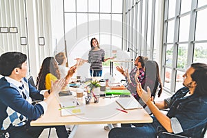 Multiethnic diverse group of creative team or business coworker clap hands in project presentation meeting leading by Asian woman