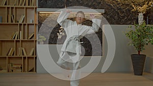 Multiethnic elementary age karate fighter practicing roundhouse kick indoors