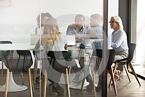 Multiethnic employee brainstorm discuss ideas together in boardroom