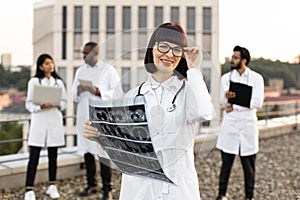 Multiethnic employees of clinic working on devices with results of examination.