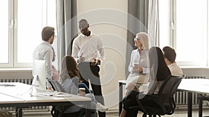Multiethnic employees speak discussing ideas during casual meeting