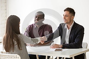 Multiethnic employers greeting female job candidate with handsha