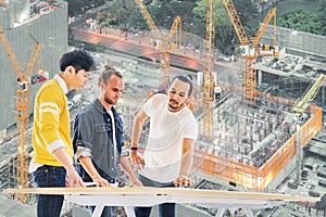 Multiethnic engineer, architect team work together on building development project planning, under construction site background