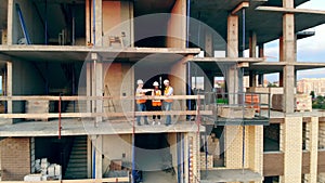 Multiethnic engineers, architects discussing construction plan. Builders check house on a construction site.