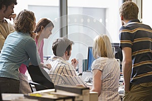 Multiethnic Executives Around Colleague Using Computer