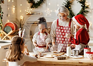 Multiethnic family, grandmother and three little kids, cooking Christmas cookies together in kitchen