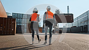 Multiethnic Female Industrial Engineer with Tablet Computer and Male Foreman Worker in Hard Hats and