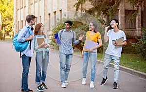 Multiethnic Freshmen Students Talking Walking In University Campus Outside photo