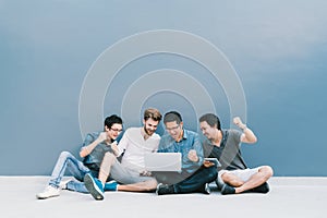 Multiethnic group 4 men celebrate together using laptop computer. College student, information technology gadget education concept