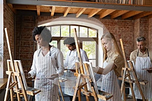 Multiethnic group of artist students drawing at easels