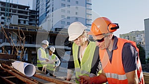 Multiethnic group of engineers and architects analyzing concentrated the plan of construction site they make some