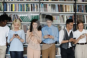 Multiethnic group of freshman students engaged in cellphone using photo