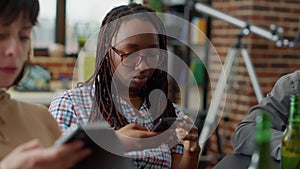 Multiethnic group of friends sitting together and using smartphone