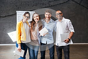 Multiethnic group of happy young business people standing in office