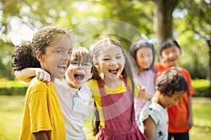 Multiethnic group of school children laughing and embracing