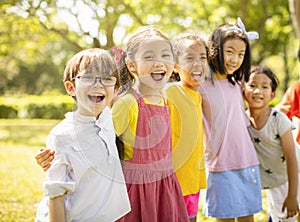 Multiethnic group of school children laughing and embracing