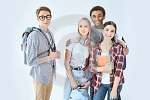 multiethnic group of teenagers with backpacks looking at camera photo