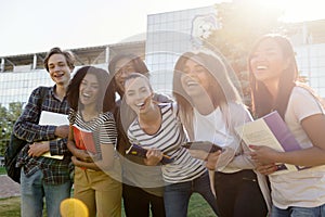 Multiethnic group of young cheerful students standing outdoors
