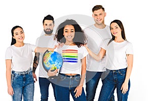 multiethnic group of young people touching shoulders of african american woman with lgbt sign on t-shirt holding globe isolated