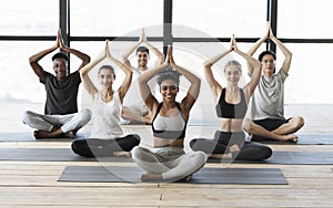 Multiethnic group of young sporty people practicing yoga indoors