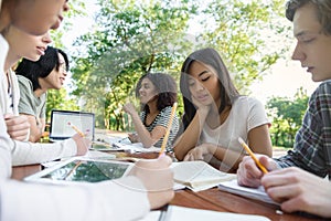 Multiethnic group of young students sitting and studying