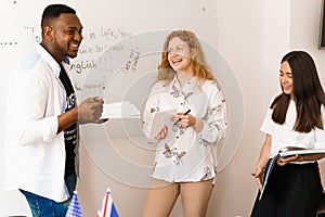 Multiethnic happy students and black teacher study foreign languages and smile and laught together in class. Studing