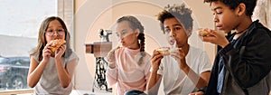 Multiethnic kids eating pizza, horizontal cropped image