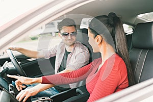 Multiethnic lover couple traveling together by car, using radio screen or GPS navigation system. Love or transportation technology