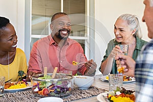 Multiethnic mature men and women eating lunch