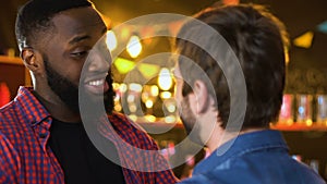 Multiethnic men hugging in pub, long-awaited meeting of two old friends, relax