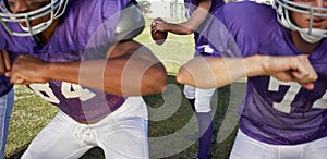 Multiethnic players playing American football on field