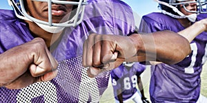 Multiethnic players playing American football on field