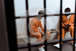 multiethnic prisoners playing chess behind