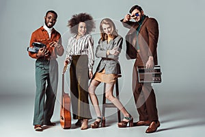 multiethnic retro styled friends with guitar and vintage radio