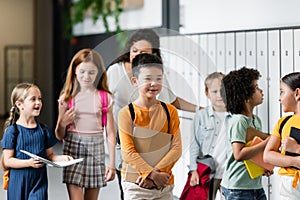 multiethnic schoolkids walking along school corridor