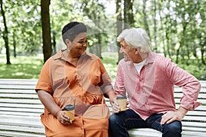 Multiethnic senior couple enjoying date outdoors and sitting in park