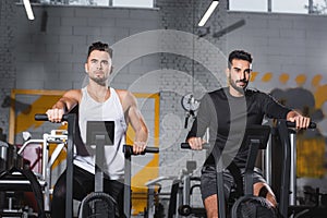 Multiethnic sportsmen training on elliptical trainers