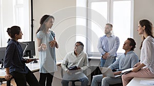 Multiethnic staff listens to African business coach during morning briefing