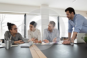 Multiethnic startup team gathering in office, discussing project