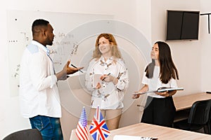 Multiethnic students and teacher study foreign languages together in class. Studing with laptop. Black handsome student