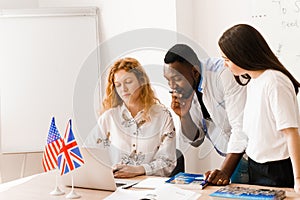 Multiethnic students and teacher study foreign languages together in class. Studing with laptop. Black handsome student