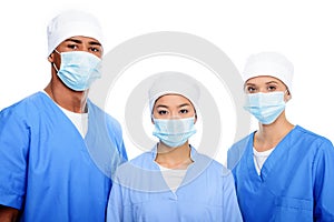 multiethnic surgeons in medical masks and caps,
