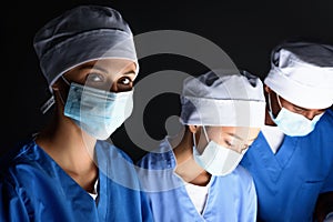 multiethnic surgeons in medical masks on operation,