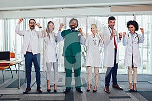 Multiethnic team of doctors in hospital looking at camera and look happy