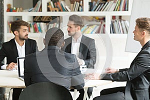 Multiethnic team of male coworkers discussing corporate plans du