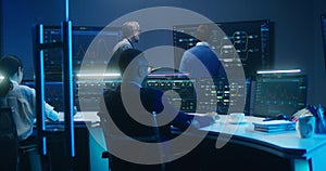 Team of IT technical specialists and software programmers work in monitoring office