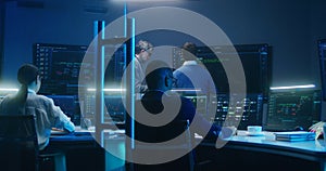 Team of IT technical specialists and software programmers work in monitoring office