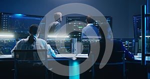 Team of IT technical specialists and software programmers work in monitoring office