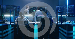 Team of IT technical specialists and software programmers work in monitoring office